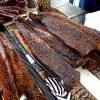 Traditional South African biltong beef strips seasoned with spices displayed on a patterned tablecloth.
