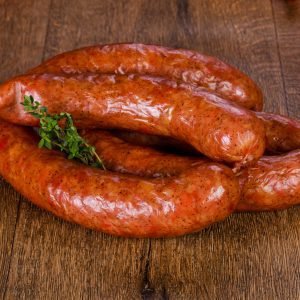 A close-up of Russian sausages arranged on a wooden cutting board