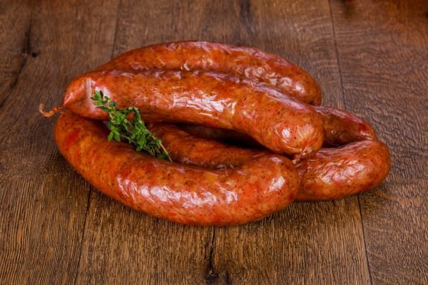 A close-up of Russian sausages arranged on a wooden cutting board