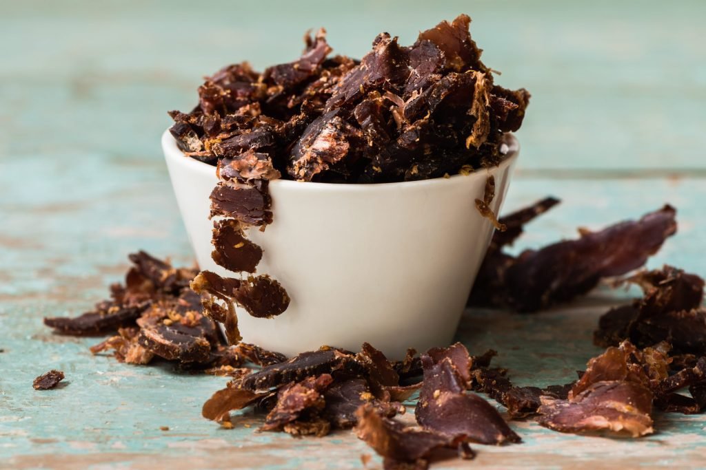 Bobaas Biltong Sliced Dry – Netvleish White bowl of Bobaas Biltong Sliced Dry on teal surface