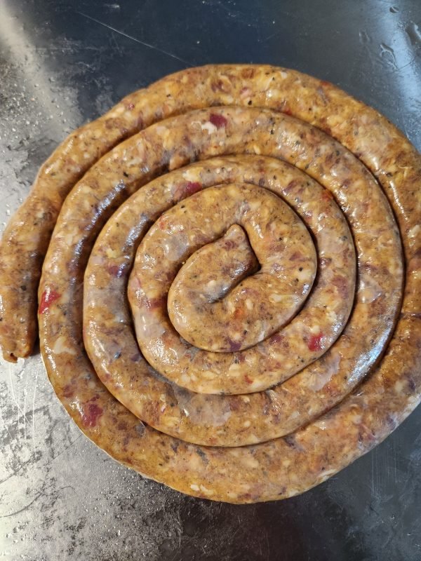 Vacuum-packed Hot Masala Lamb Sausage with visible ingredients label and NETvleish logo, spicy coiled sausage made in Canada